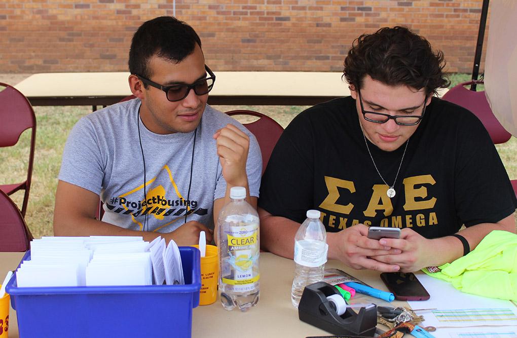 Frank Cruz, marketing junior, and Enrique Flores, biolog sophomore, wait for students to check in at the McCullogh-Trigg Check in point on Move In Day, Tuesday August 18, 2015. Photo by Rachel Johnson