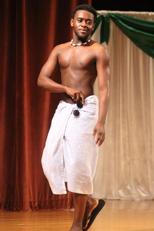 Preston Busby, criminal justice junior, takes the sunglasses off from around his towel before removing his towel to reveal his swimsuit during the swim wear portion of the 2017 Mr. and Miss Caribfest Pageant held in Akin Auditorium Sept. 28. Photo by Marissa Daley