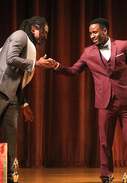 Rocksen Jean-Louis, music sophomore, leans in to give Edward Collins, psychology freshman, a handshake after Collins was announced 2017 Mr. Caribfest at the Mr. and Miss Caribfest Pageant held in Akin Auditorium Sept. 28, where about 300 people were in attendance. Photo by Marissa Daley