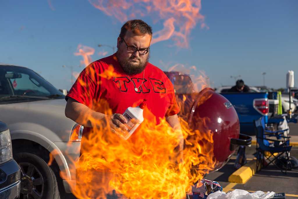 Adam Edwads is firing up the bbq during the tailgate party before the start of the football game against Angelo State on Oct. 15. Photo by Izziel Latour
