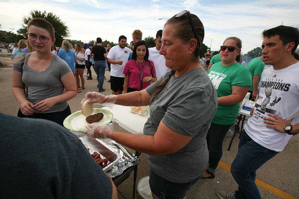 Patty Gilmore serves burgers for the Baptist Student Ministry. Photo by Bradley Wilson
