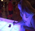 Emily Burns, theatre freshman, drawing on the shuffleboard table at the GloCade in the DL Ligon Coliseum on Aug 24. Photo by Kayla White.