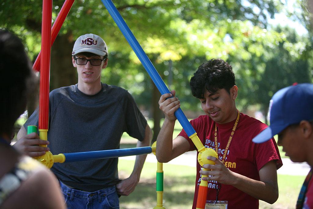 With friends on the orange team, Orlando Espinoza, psychology freshman, builds a structure on the Quad as part of Roundup Olympics while Jared Byrne, radiology freshman, watches. Photo by Izziel Latour