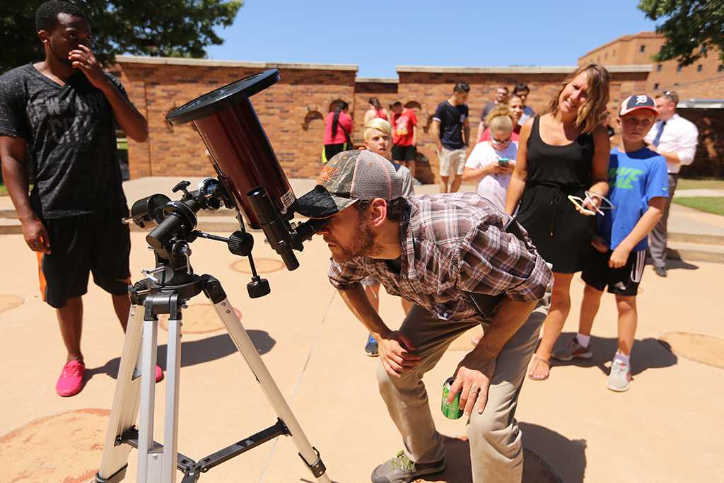 Nate Blank, a stock room manager in the chemistry department, looks through a telescope with a neutral density filter at the solar eclipse watch party Aug. 21, 2017 on Sunwatcher Plaza at Midwestern State University. Photo by Bradley Wilson