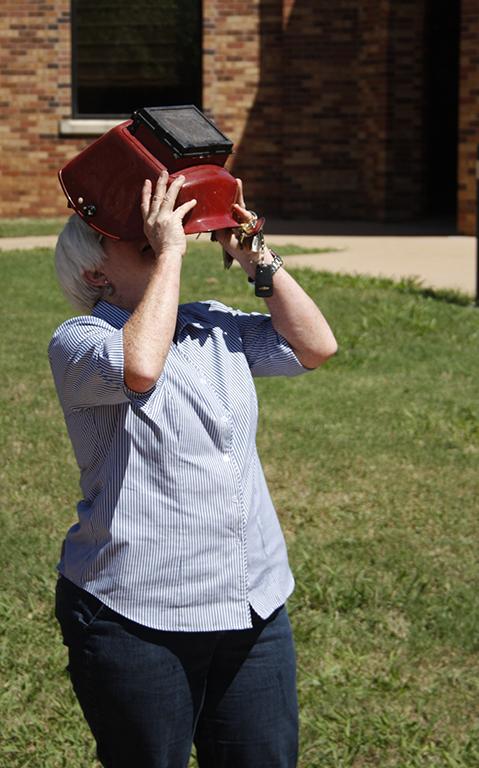 Sandra Shawver, assistant professor of kinesiology, watches the solar eclipse with a welding helmet on in the Sunwatcher Plaza on Aug. 21.Photo by Justin Marquart