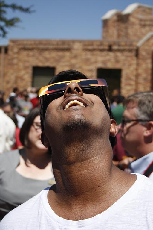 Eric Arumugam, campus visitor, loks up at the sun during the solar eclipse at Sunwatcher Plaza on Aug. 21. Photo by Justin Marquart