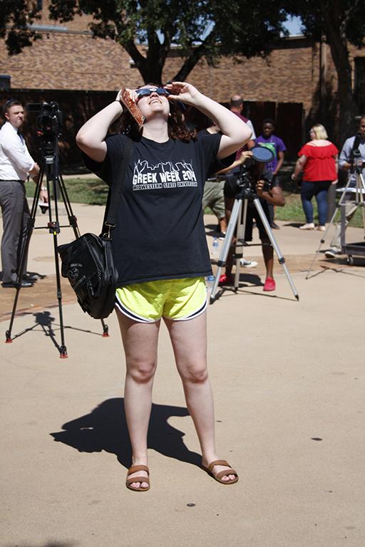 Kara McIntyre, mass communication senior, looks up at the sun during the solar eclipse at Sunwatcher Plaza onAug. 21. Photo by Justin Marquart