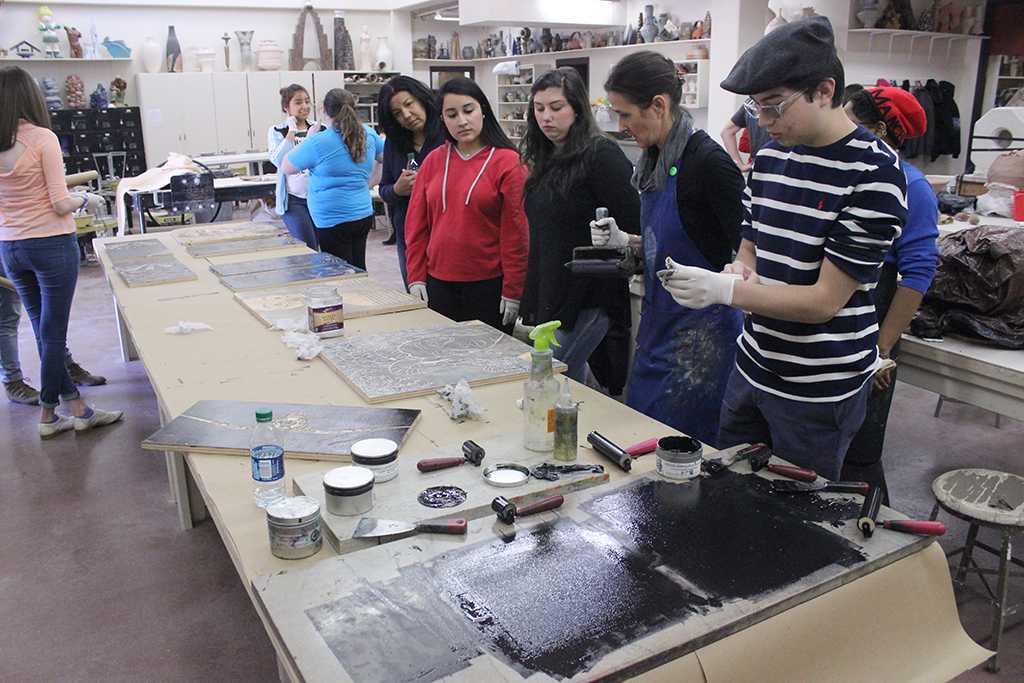 Catherine Prose, associate professor, demonstrates to students how to properly roll ink onto the wood block for the Steamroller Print Event on Nocona Trial set up as a collaboration between MSU's Harvey School of Visual Arts and Wichita Falls Independent School District high schools, Feb 9, 2016. Photo by Francisco Martinez