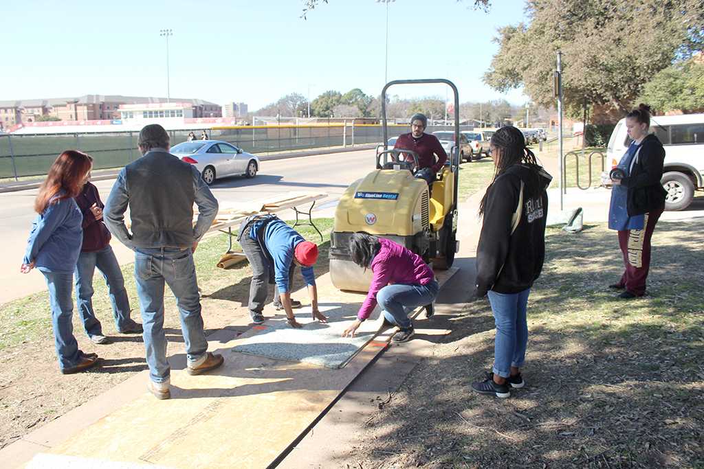 Faculty and students gather outside of Fain Fine Arts for the Steamroller Print Event on Nocona Trial set up as a collaboration between MSU's Harvey School of Visual Arts and Wichita Falls Independent School District high schools, Feb 9, 2016. Photo by Francisco Martinez