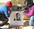 Lizca Bass, painting senior, and Auria Sanchez, teaching certification senior, unpeel the paper from the wood block to reveal the image for the Steamroller Print Event on Nocona Trial set up as a collaboration between MSU's Harvey School of Visual Arts and Wichita Falls Independent School District high schools, Feb 9, 2016. Photo by Francisco Martinez