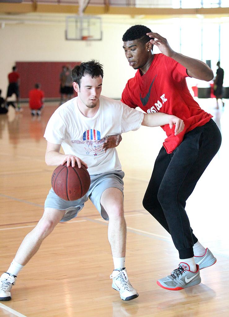 Zach Davis, junior, dribbles past Jamal Davis, sports and leisure sophomore, and passes the ball to his teammate to make sure the shot during the basketball tounament, Swishes 4 Wishes, put on by Chi Omega, March 12. Photo by Rachel Johnson