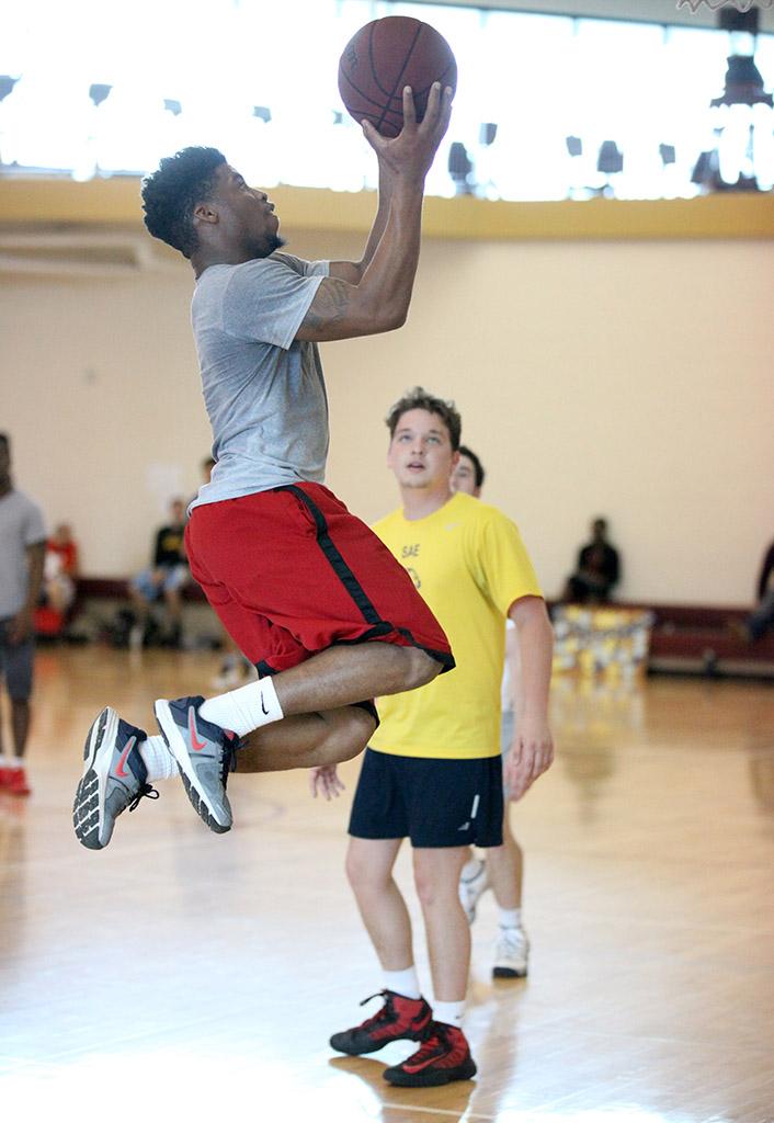 Diamond Williams, kinesiology sophomore, does a lay up, making the basket for his team, The Lightbulbs, in their game against Sigma Alpha Epsilon, during Swishes for Wishes, put on by Chi Omega March 12. Photo by Rachel Johnson