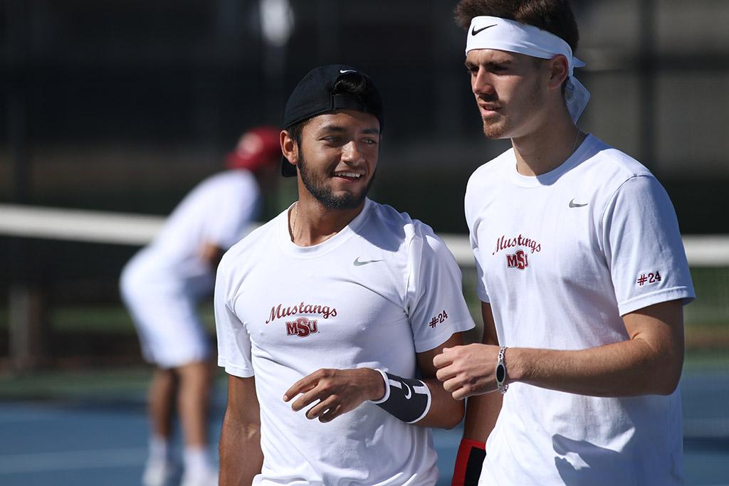 Angel Palacios, business management sophomore, and Joshua Sundaram, mechanical engineering sophomore, talk as they walk to their court positions during the Collin College vs. MSU tennis meet at MSU on Friday, Feb. 9, 2018. Photo by Francisco Martinez