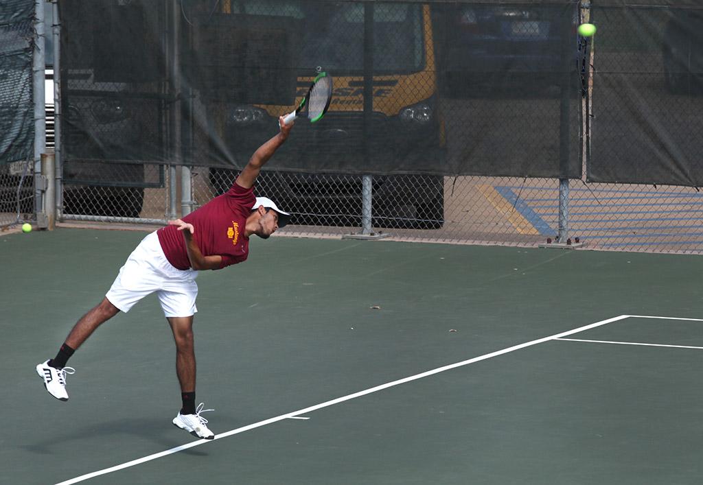 Angel Palacios, business management freshman, serves the ball to the other side during a doubles game against Metro State at the MSU Tennis Center. Photo by Rachel Johnson