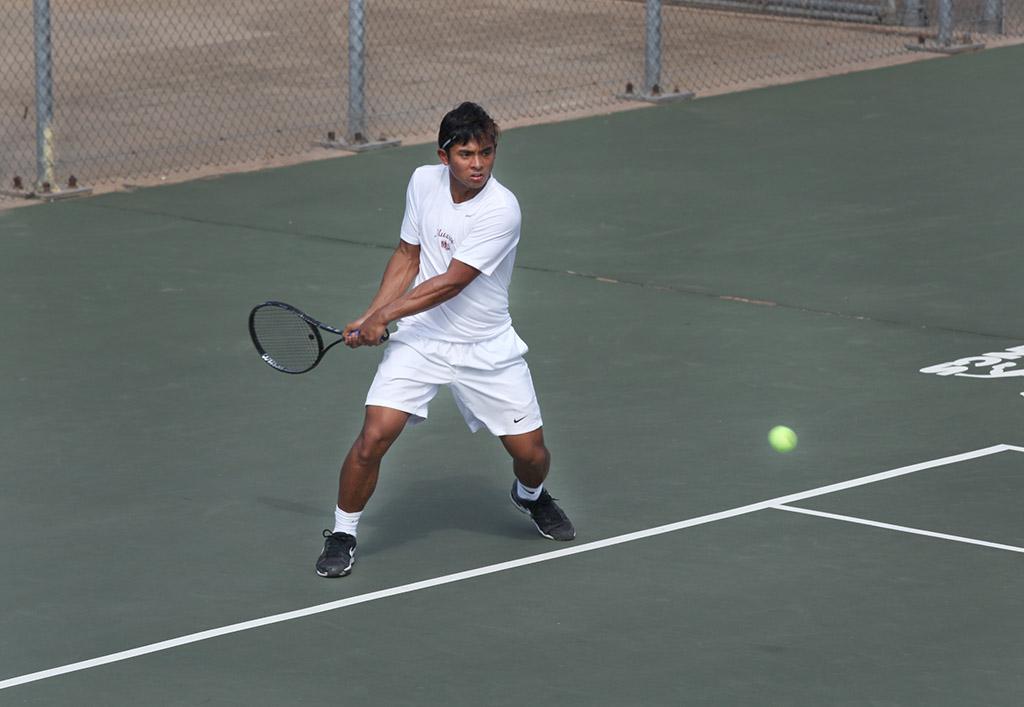 Dillon Pineda, biology sophomore, returns the ball to the other side during a doubles game against Metro State at the MSU Tennis Center. Photo by Rachel Johnson