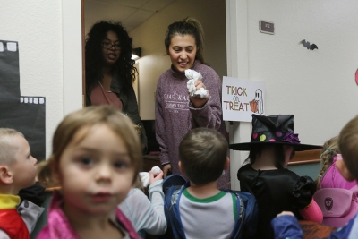 Dea Vukataha, biology sophomore, passes out candy while her roommate, Shakira Hernandez, biology freshman, looks on while the kids of YMCA trick or treat in Killingsworth Residence Hall at Midwestern State University. Photo by Justin Marquart