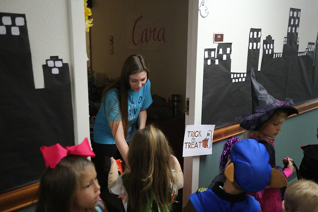 Cara Haitt, nursing freshman, passes out candy while the kids of YMCA trick or treat in Killingsworth Residence Hall at Midwestern State University. Photo by Justin Marquart