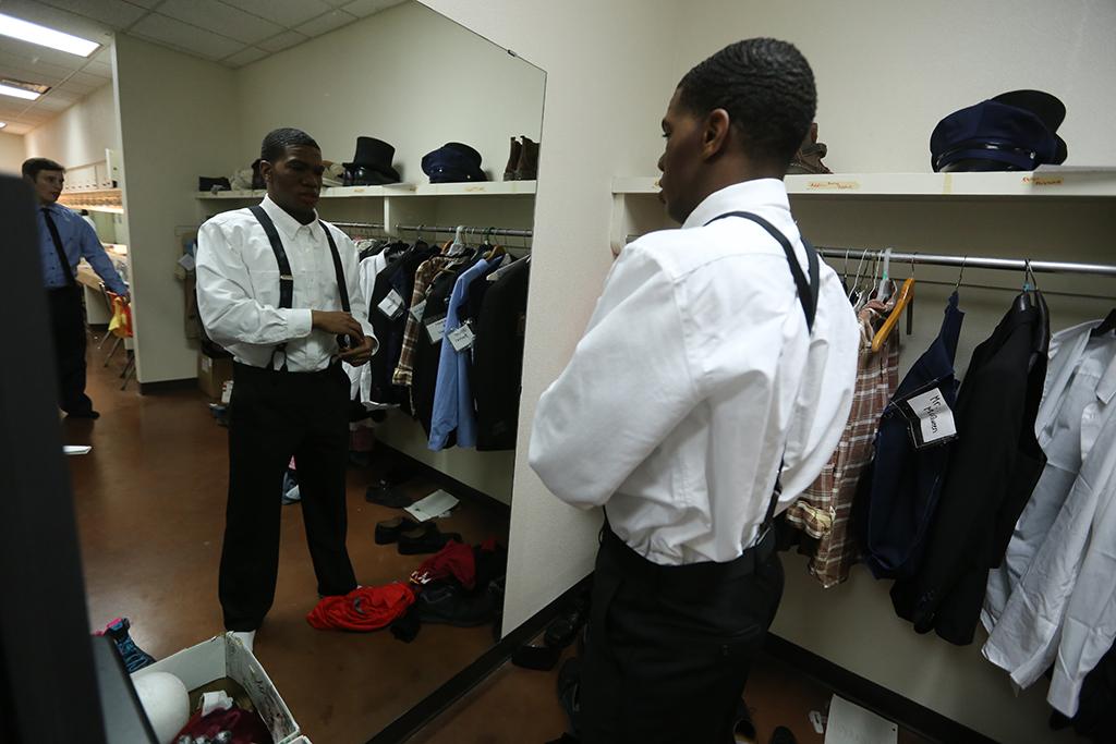 Kendall Jones puts on his Senator Fipp costume before the first dress rehearsal of "Urinetown," Feb. 18. Photo by Bradley Wilson