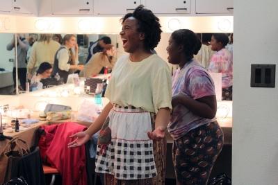 Nicole Smalls getting her bandana tied by Kaylor Winter-Roach for one of her characters at pre-show Urinetown on February 18, 2018 Photo by: Avery Whaite