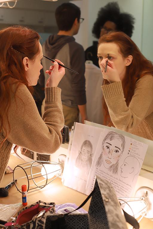 As a way to practice the make-up design for her character Little Sally, Kalli Root, english junior, looks at the sheets as reference while she does her makeup for the first time in the dressing room on Friday, Feb.16, 2018. Photo by Joanne Ortega