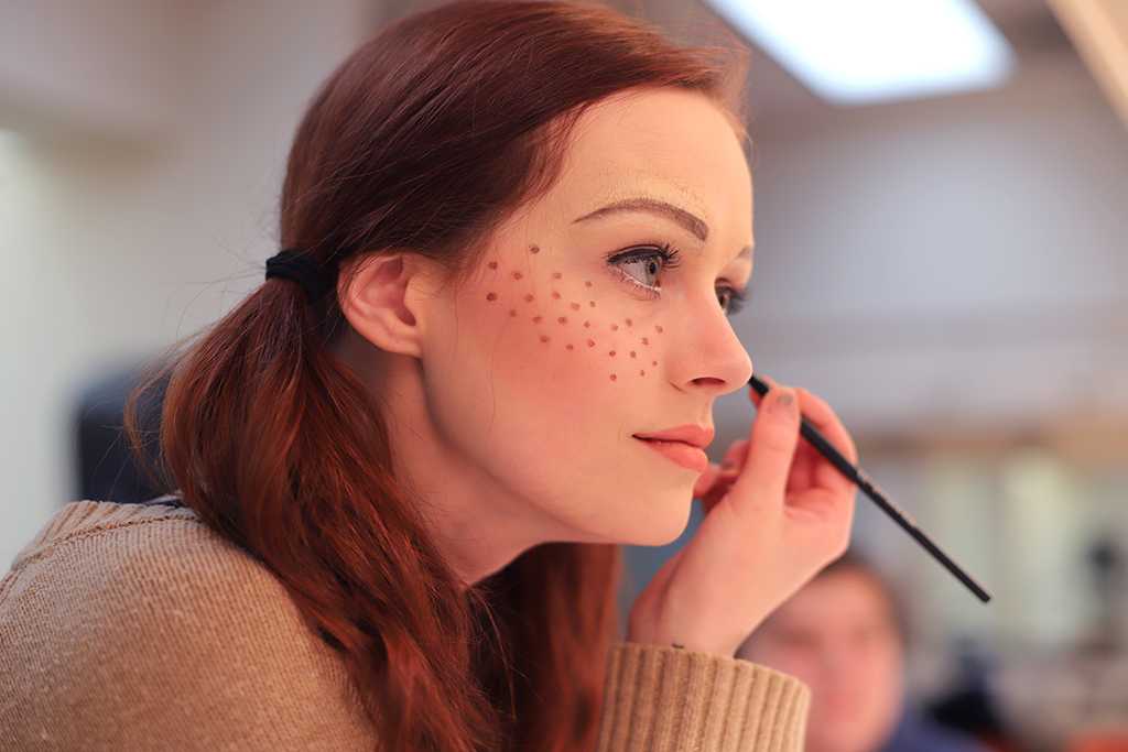 Kalli Root applies makeup for Urinetown in the dressing room on Feb. 16, 2018. Photo by Sarah Graves