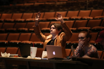 Ron Harle joins the cast in waving at rehearsal for the Midwestern State University production of Urinetown. Photo by Bradley Wilson