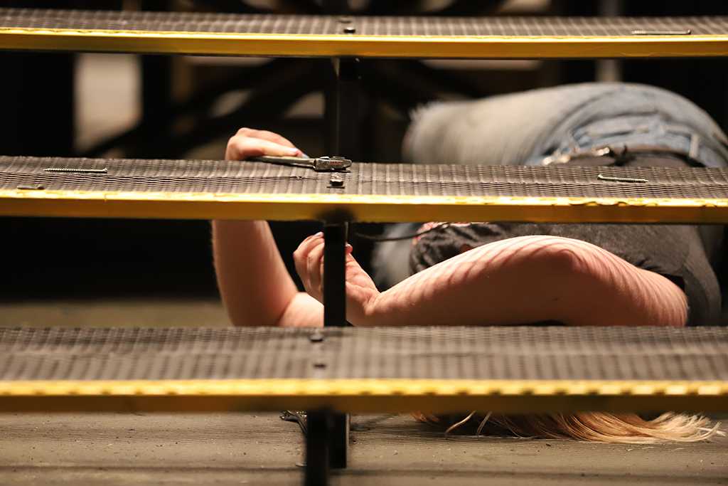 Emily Burns, theater junior, disassembles stairs on the platform on the Urinetown set on Monday, March 5, 2018. Photo by Jeromy Stacy