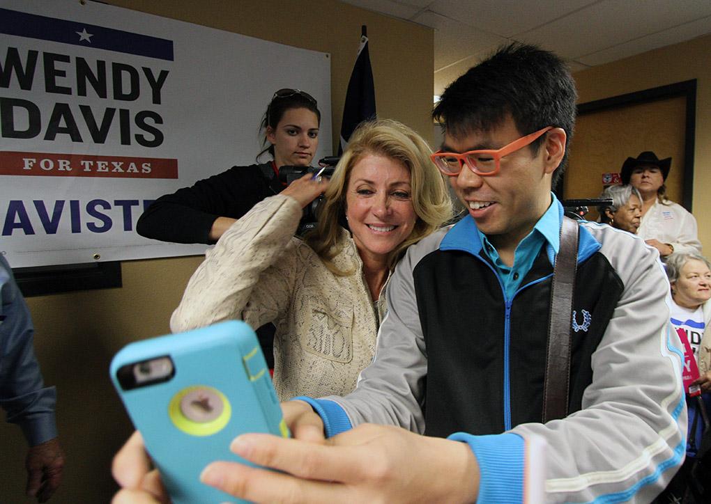 Wendy Davis, gubernatiorial candidate, takes a selfie with Newman Wong, research analyst for Institutional Research at Midwestern State University, at the Wichita Falls County Democrats headquaters Saturday, Nov. 1, 2014. Photo by Lauren Roberts