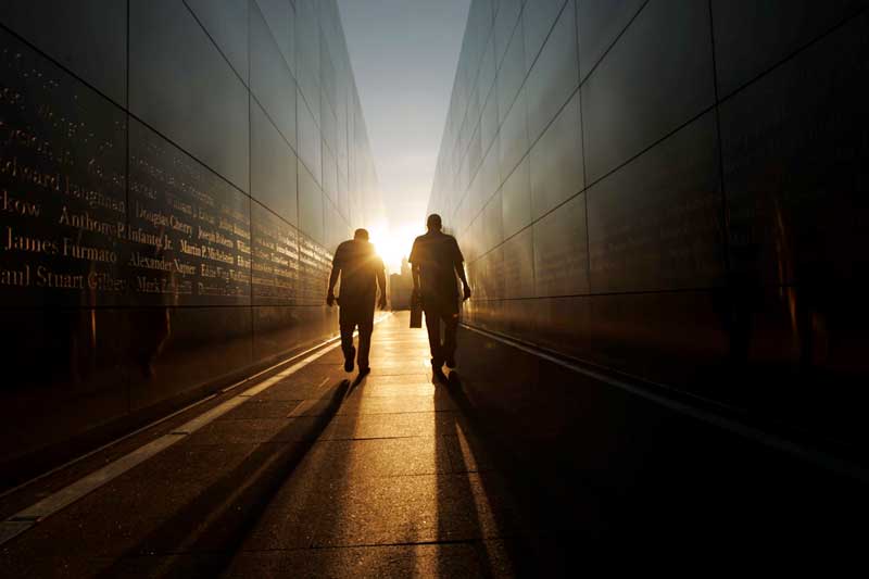 Two men walking toward the sun at the 9/11 memorial at Liberty State Park in New Jersey. Photo by Kevin Wexler/MCT