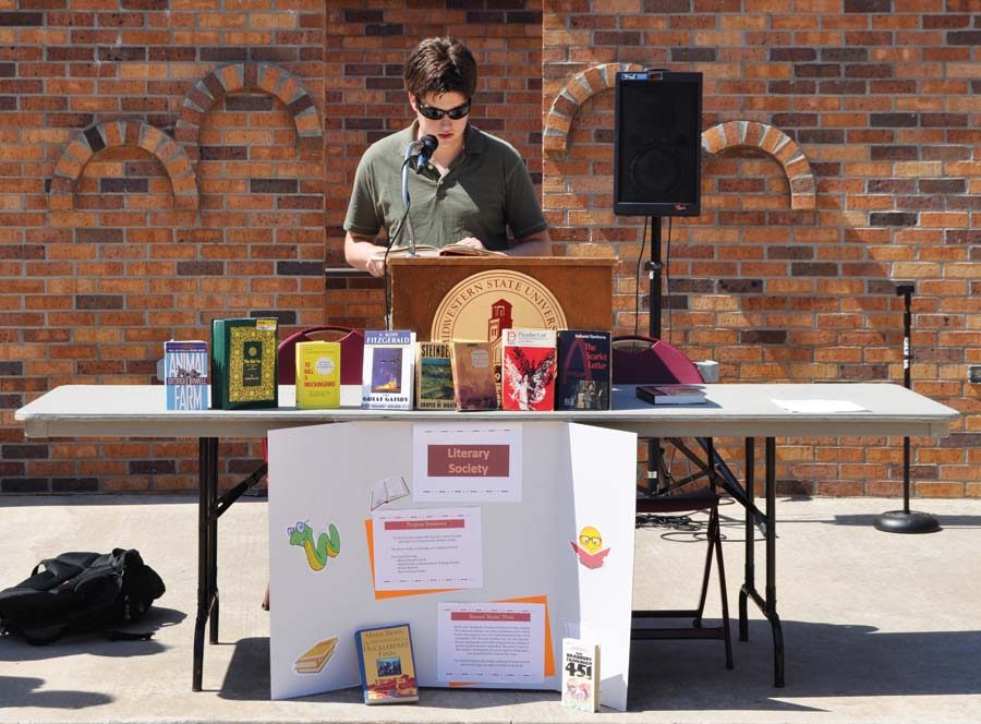 Derek Baker seen Tuesday afternoon reading from the book Brave New World by Aldous Huxley. (Photo by Hannah Hofmann)