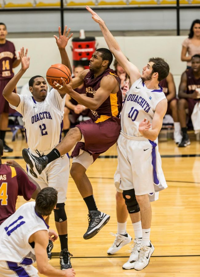 Junior guard Monzaigo Williams drives to the hoop amidst Ouachita Baptist defenders. Williams dropped in 13 points in the Mustangs’ loss. 
Courtesy Photo