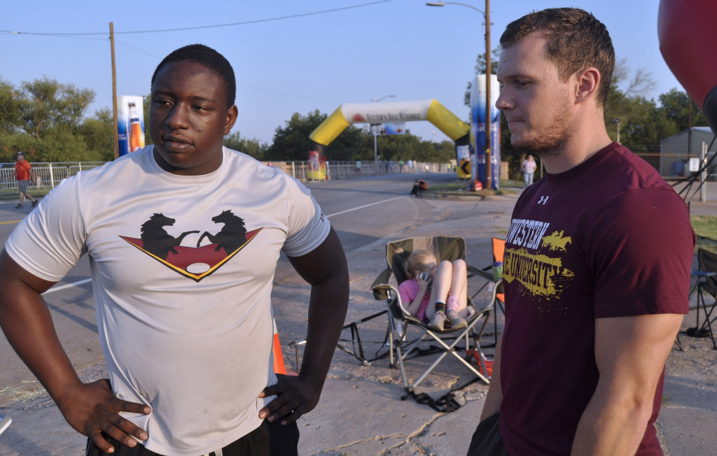 Simba Musarurwa (left), rugby president and senior Computer Science major, and Matt Davis (right), MSU alumni, discuss their efforts in helping set up the Pyro Pete at Hotter 'N Hell Hundred.