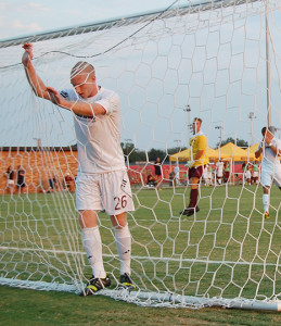 Forward Darin Kruzich, junior in radiology, drops his head down against the net, while his teammates look on, as Fort Collins' first goal rebounds back onto the field.