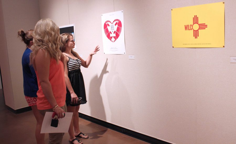 Sarah Adams, a junior in  kinesioloy, Collin Darland, a senior in art education, and Kelby Doughty, a senior in sports management look at the posters during the opening. The art is very interesting, I enjoy the way he uses print making in the music field, Darland said.