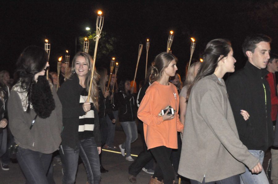 A line of students carries torches down Council Drive on the Midwestern State University campus during the Torchlight Parade of the 2013 MSU Homecoming festivities.