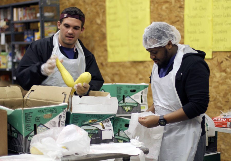 Trey Holt, junior in education, and Yani Muskwe, sophomore in computer science, help sort fresh produce at the Wichita Falls area food bank Jan. 20.