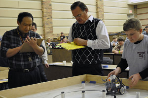 Sheldon Wang, professor and chair of the McCoy School of Engineering, and Richard P. Simpson, an assistant professor in computer science, judge Dayde Whitworth’s robot for the TCEA Area 9 Robotics Competition at the Dillard College of Business on Jan. 25.