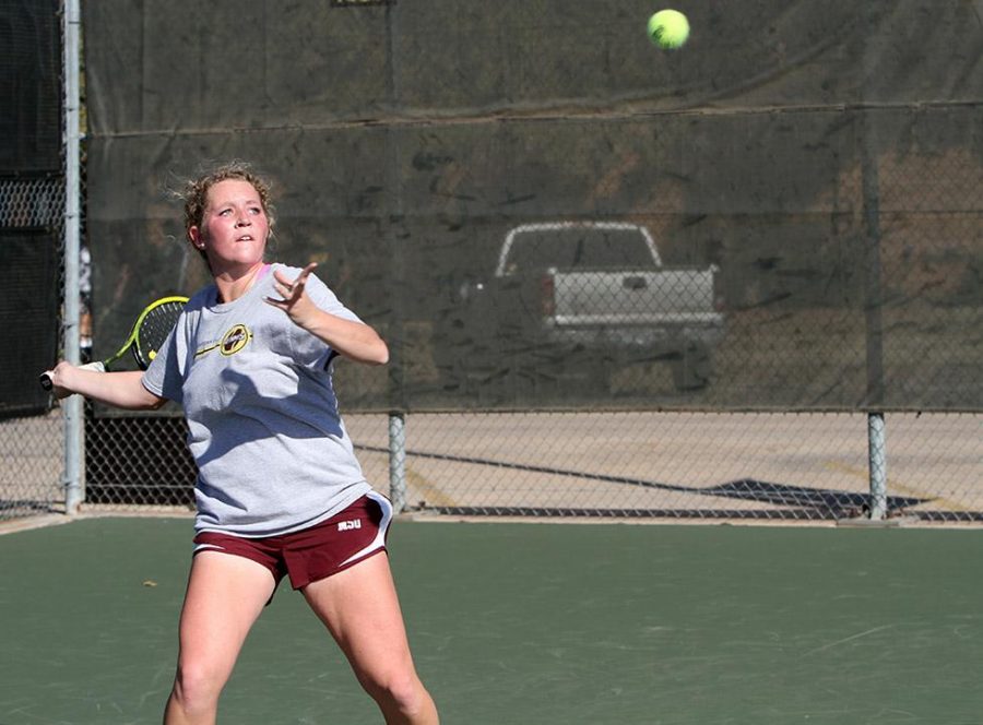 During practice Tuesday Madeline Schorlemmer, sophomore in psychology, goes through hitting drills on the tennis courts. The tennis teams have games starting at noon Friday against Metro State and at 10 a.m. Saturday against the University of Arkansas-Fort Smith.  Photo by Lauren Roberts