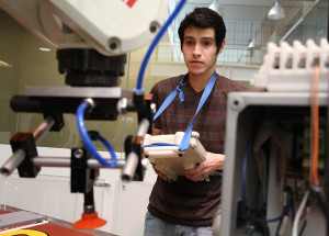 Alejandro Hernandez, senior in mechanical engineering, works on his senior design project using a hydraulic peck-drill in the McCoy training lab Tuesday afternoon. Photo by Eddie Miller