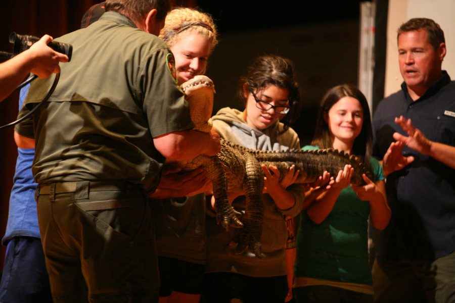 Jeff Corwin interacts with members of the audience, Madison Brechbulh, nursing freshman, Amy Calderon, freshman in athletic training, and other students on stage as he talks about an alligator during his visit to Midwestern State University, Artist Lecture Series, Oct. 2, 2014. Photo by Sam Croft