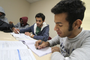 Saleh Alhariqi and Nawaf Almutairi go through English workbooks in the Intensive English Language Institute conversation and grammar class Tuesday. Photo by Lauren Roberts