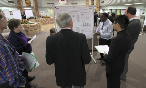 Lance Henry, mechanical engineering senior explains "Mathematical Aspects of a Multi-geared Transmission in Wind Turbine Technology" to judges Nov. 21, 2014 during the Undergraduate Research and Creative Activity forum poster presentations in the Clark Student Center. Photo by Lauren Roberts