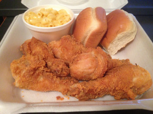 Fried chicken legs, macaroni and cheese, and two bread rolls from The Chicken Box.