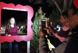 Kedisa Alexander, accounting senior,  and Ariel Douglas, finance senior, takes Kendall Stewart's, respiratory therapy junior, picture during the Fantasy of Lights Opening Ceremony, Monday night infront of the Hardin Building. "My favorite thing about this was that it get's me in the mood for Christmas," Stewart says. Photo by Rachel Johnson