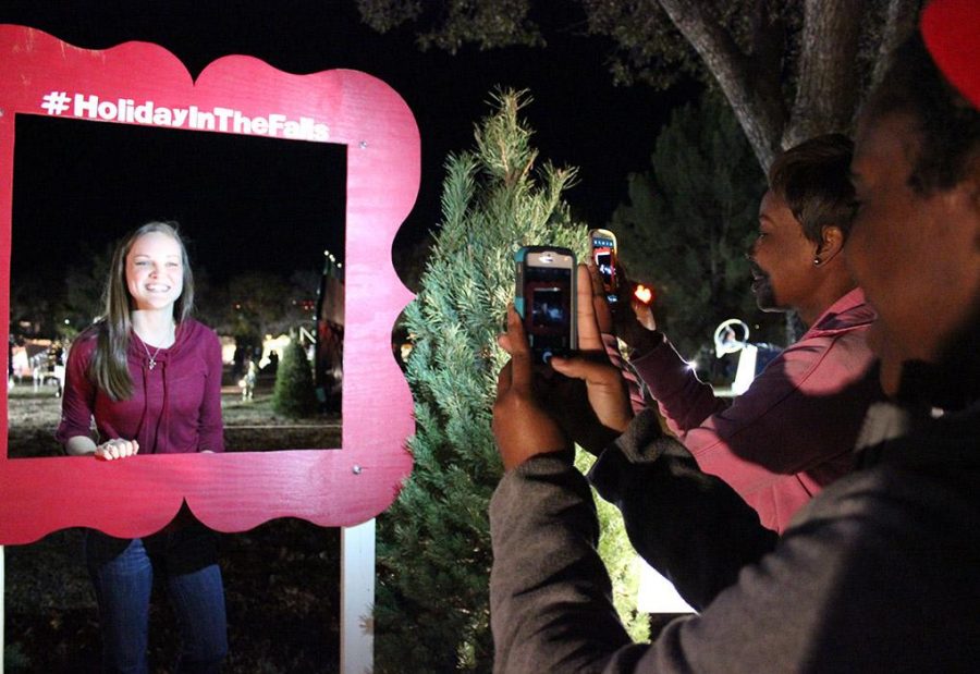 Kedisa Alexander, accounting senior,  and Ariel Douglas, finance senior, takes Kendall Stewarts, respiratory therapy junior, picture during the Fantasy of Lights Opening Ceremony, Monday night infront of the Hardin Building. My favorite thing about this was that it gets me in the mood for Christmas, Stewart says. Photo by Rachel Johnson