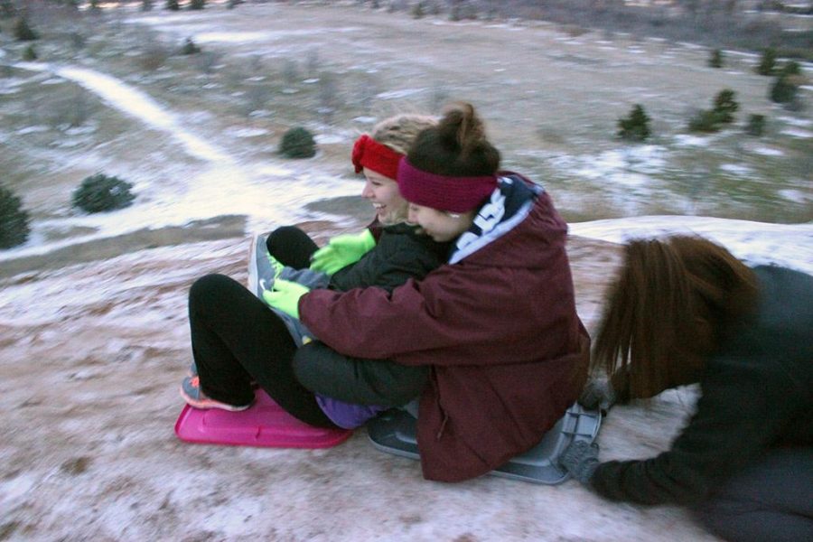 Alexis Carrizales, biology freshman, pushes Norma Nieto, sophomore business, and Madison Brechbuhl, nursing freshman, down The Hill on makeshift sleds during the first snow day, Monday February 23. Photo by Rachel Johnson
