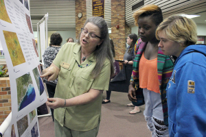 Rebecca Dodge, geosciences associate professor, explains to Shairi Stanley, art sophomore, and Alyson Baker, graphic design freshman, her research project during the Celebration of Scholarships held in the Atrium of the Clark Student Center Tuesday, April 28, 2015. Photo by Rachel Johnson
