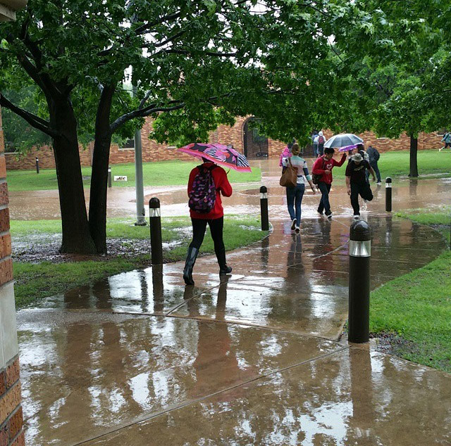 Students avoid deep puddles walking from Prothro-Yeager to Clark Student Center as the rain continues to pour down on campus April 27. Photo by Francisco Martinez