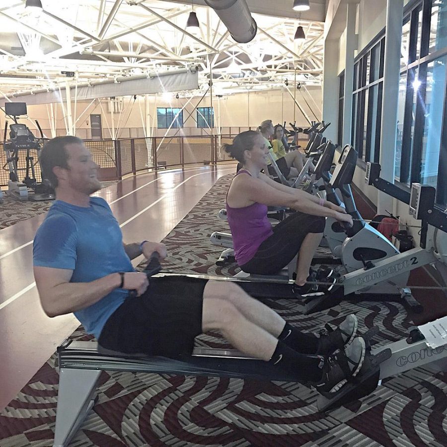Associate Director of Housing, Angie Reay and Residence Hall Director, Clint Coulter compete against each other on the rowing machine in the Wellness Center for the indoor mini-triathalon, Tuesday April 28, 2015. Photo by Jessalyn Castro