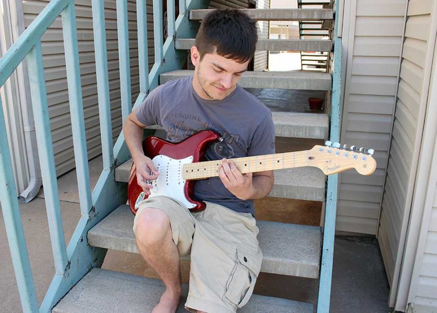 Andrew Latour, sociology sophomore, plays Everlong by Foo Fighters on his bass on the steps of the apartment building he lives in on Saturday, May 2, 2015. Photo by Rachel Johnson
